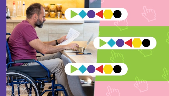 une personne en fauteuil roulant devant un ordinateur portable et de la paperasse